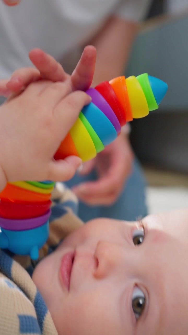 Madre che gioca con il bambino usando un giocattolo colorato