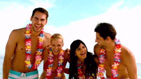friends wearing garlands and laughing on the beach
