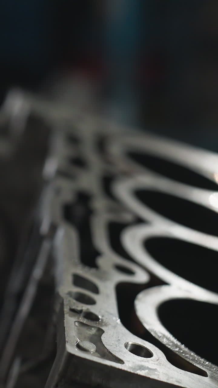 инженер-механик в промышленной мастерской, измеряющий размеры двигателя с помощью калибра вернье, сосредотачиваясь на точности, практическом процессе проверки, рабочее пространство, заполненное механическими инструментами