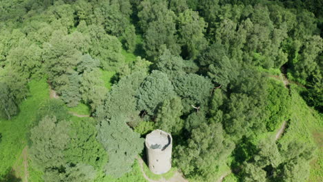 aerial top down view of a old english folly on top of a hill surrounded by countryside