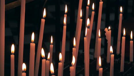 multiple candles burning brightly in a dimly lit room