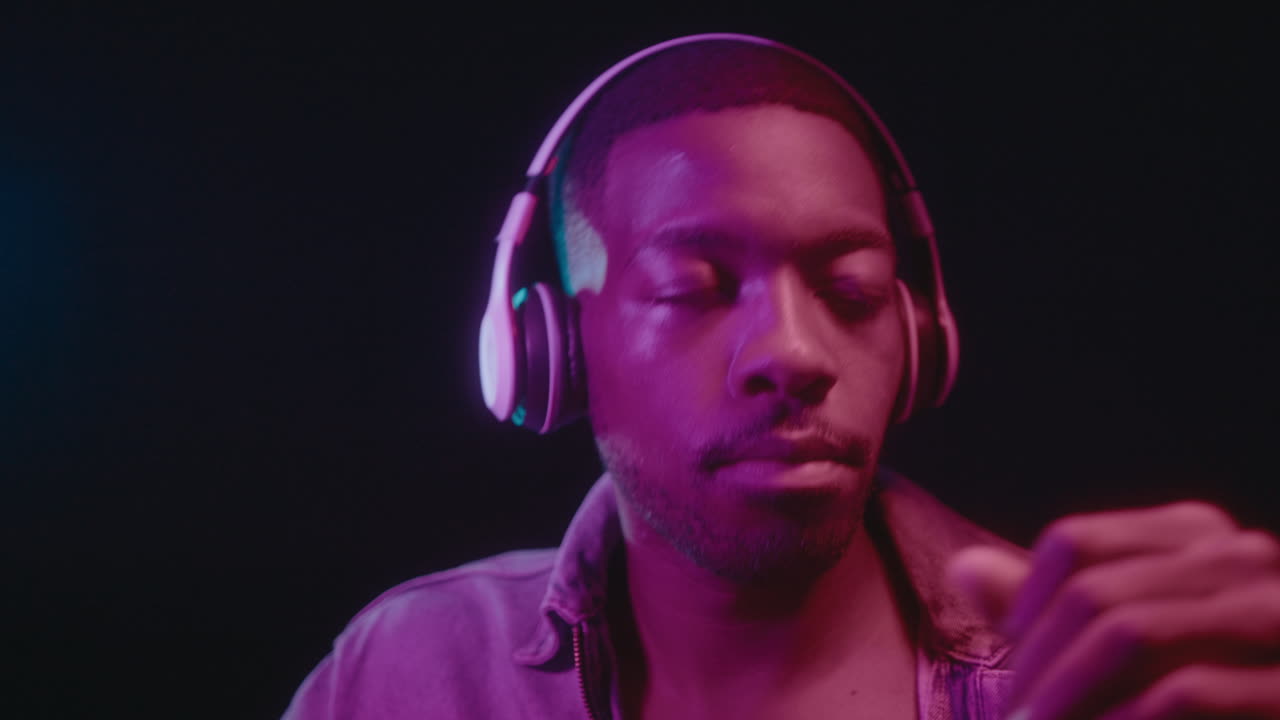 Black Man with Headphones Dancing in Neon Light