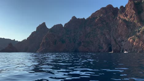 Exploring-Scandola-peninsula-nature-reserve-in-summer-season-as-seen-from-moving-boat,-Corsica-island-in-France