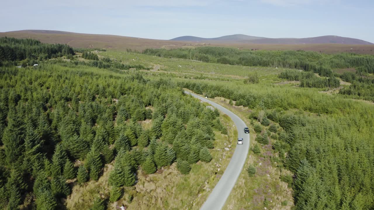 vista aérea de los coches que circulan por una larga y sinuosa carretera de montaña en las montañas de wicklow en un día soleado-7