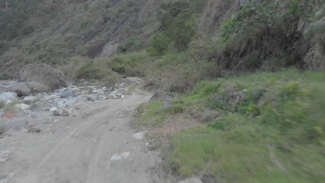 three men standing on the edge of mountain dirt road vehicle tracks leading out to riverbed opening boulders rocks sand i valley kabayan benguet philippines fast reverse revealing people aerial