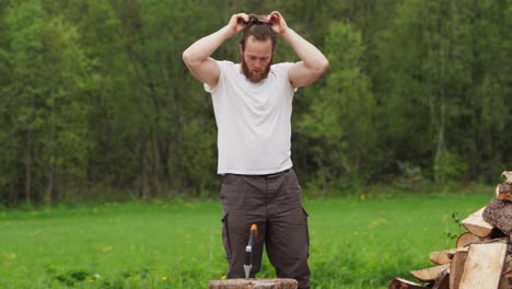 un hombre con barba dividiendo bosques en el campo