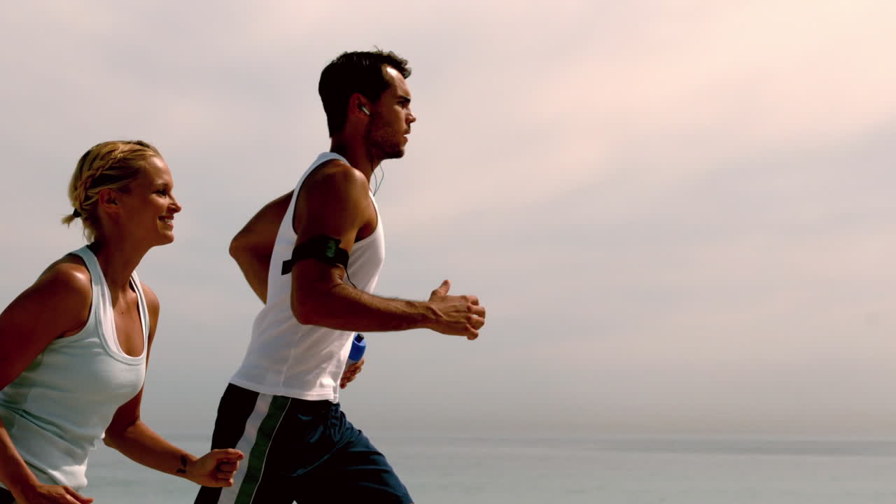 Atleti che fanno jogging lungo la spiaggia