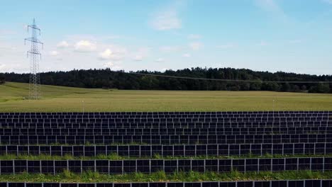 Empuje-Aéreo-Sobre-Una-Granja-De-Energía-Solar-Entre-Exuberantes-Campos-Verdes-Y-Dorados