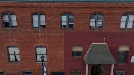 descending drone shot of american town with old buildings. red brick facade and colorful trees in autumn. sunset time in small quaint city of usa. wide shot.