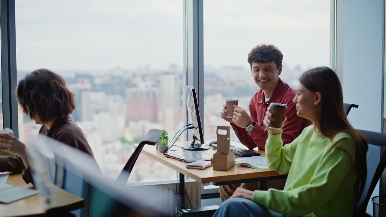 Positive colleagues toasting coffee at work break. Office coworkers having fun