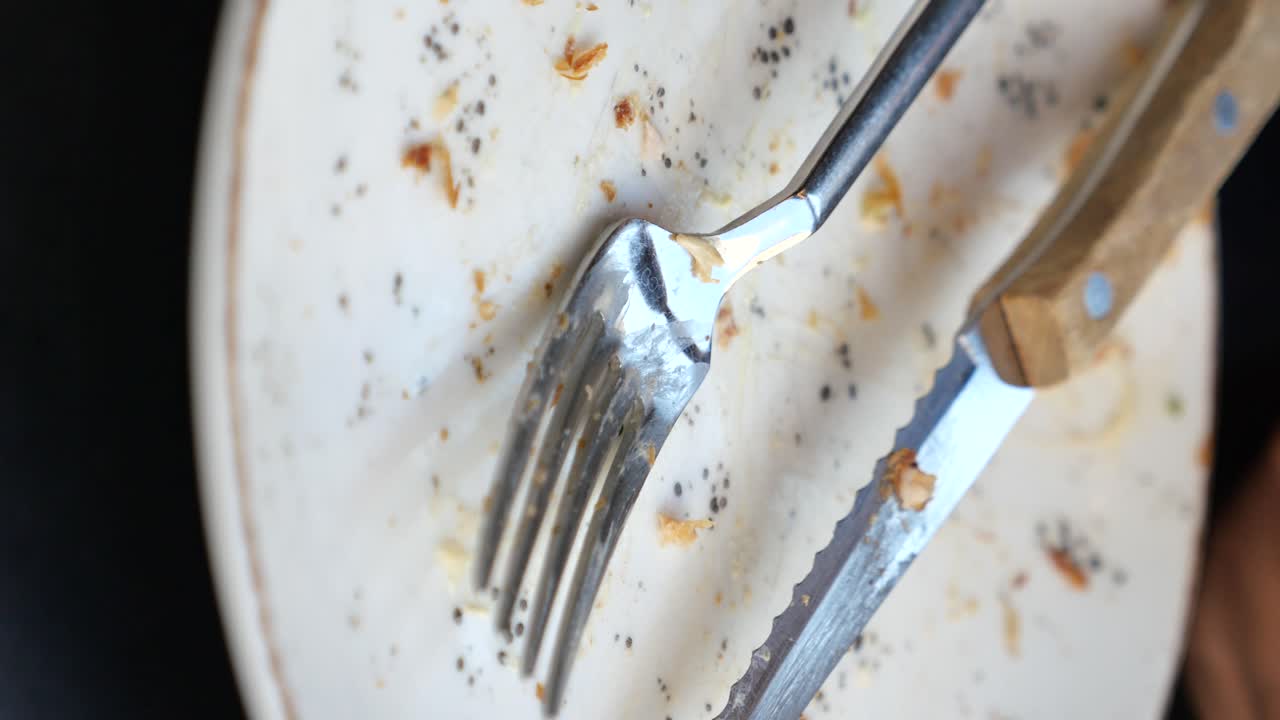 Dirty Plate with Used Cutlery and Food Remnants