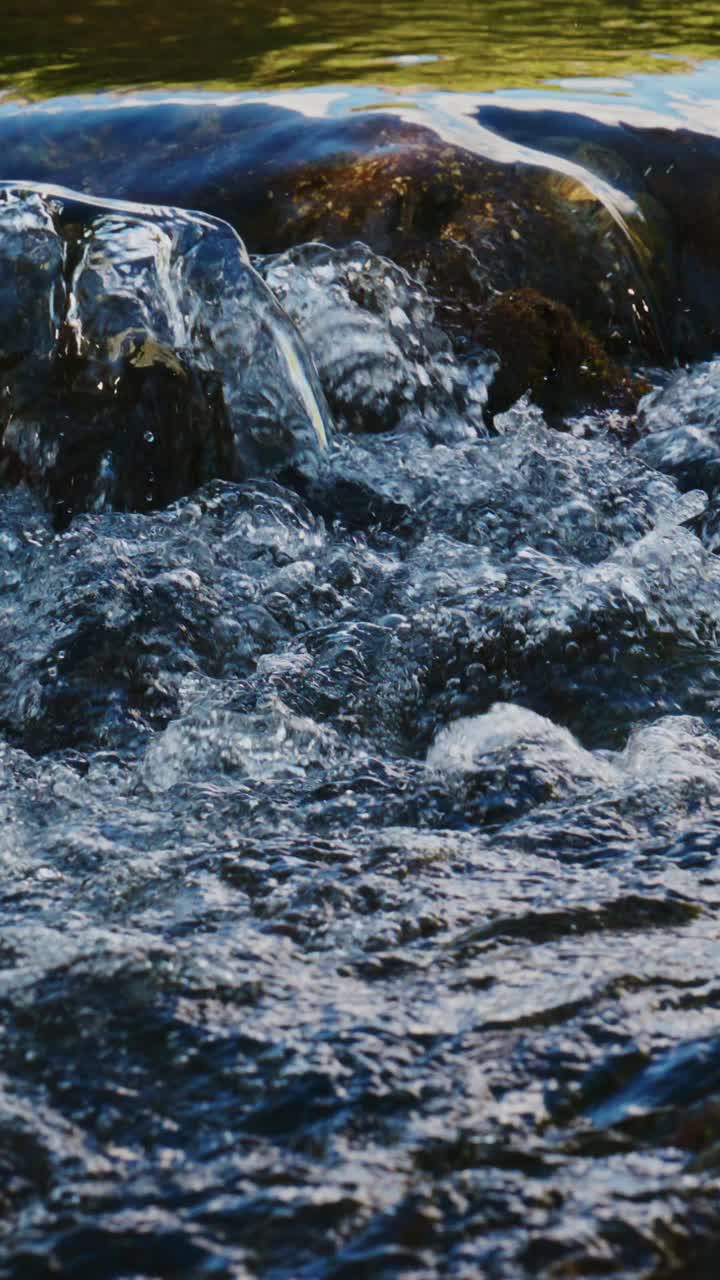 Close-up de Água Cristalina Fluindo sobre Rochas em um Rio