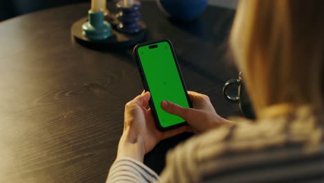 mujer usando un teléfono con pantalla verde