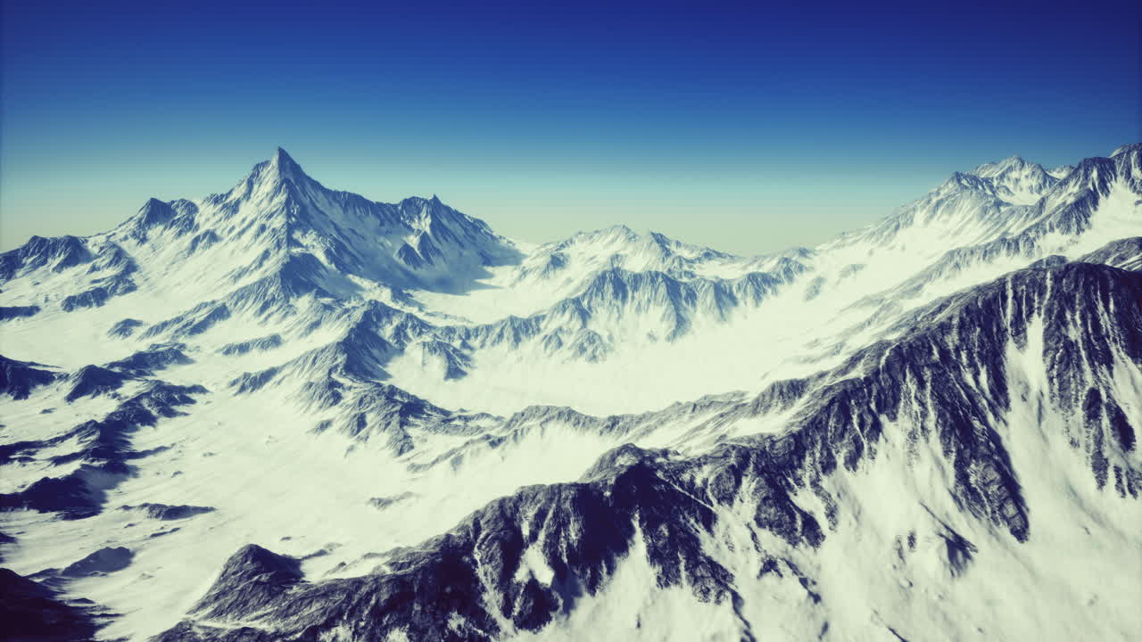 Expansive view of snow capped mountains under a clear blue sky