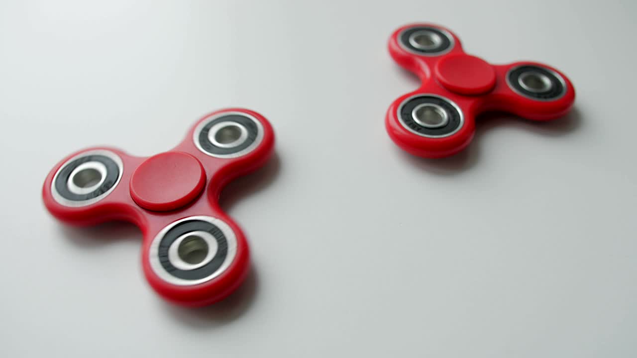 Primo piano di un popolare fidget spinner giocattolo che ruota su sfondo bianco