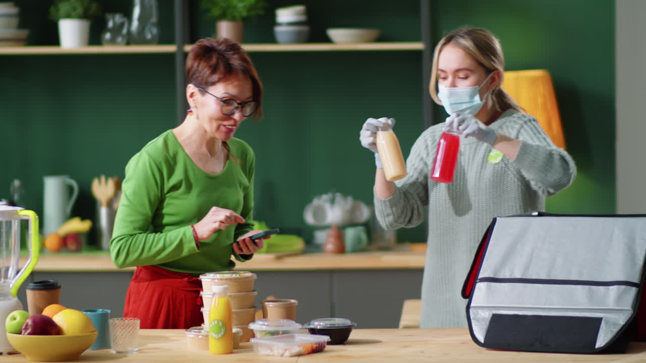 mensajero femenino con máscara y guantes descargando alimentos ecológicos para mujeres