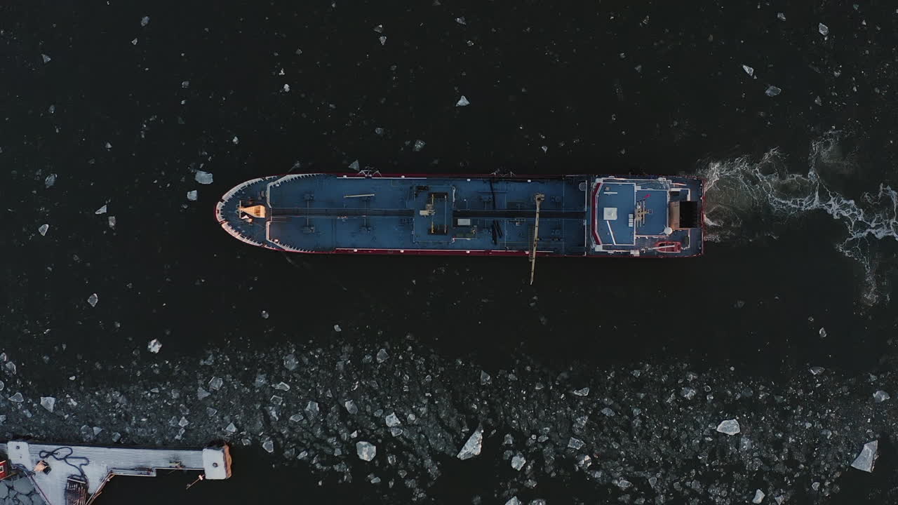 Top view zoom out drone shot of a large fishing boat.