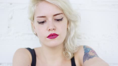 una joven rubia seria mirando fijamente a la cámara
