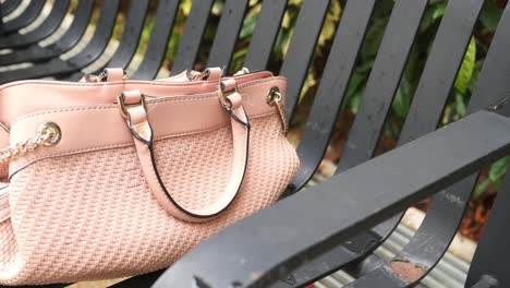 pink woven handbag on a bench