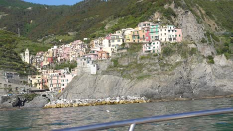 One-of-the-five-beautiful-villages-of-cinque-terre-with-colorful-houses-on-a-cliff-by-the-sea,-view-from-the-boat