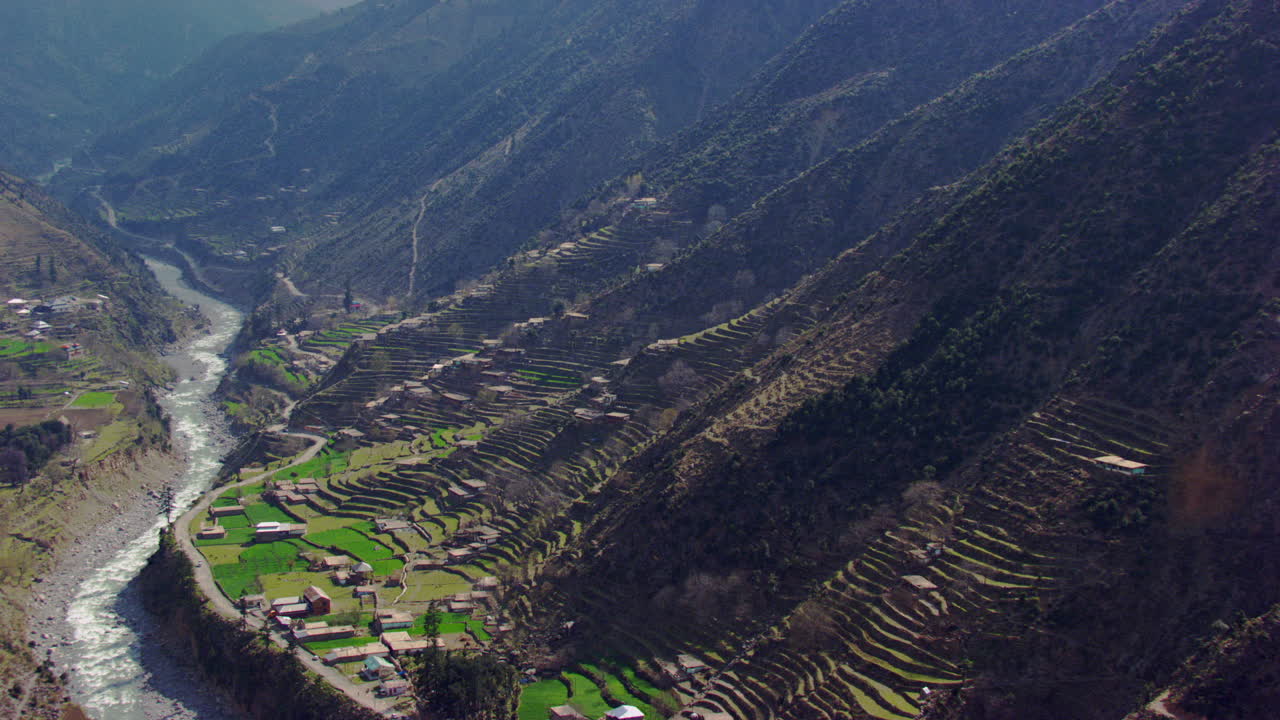 un pueblo pintoresco con hermosos paisajes de montañas y vistas aéreas del río, así como una vegetación encantadoramente diseñada con una carretera por la que circula el tráfico
