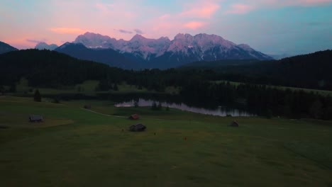 aerial shot over geroldsee field and lake with the karwendell mountain range in the background at sunset, bayern, germany