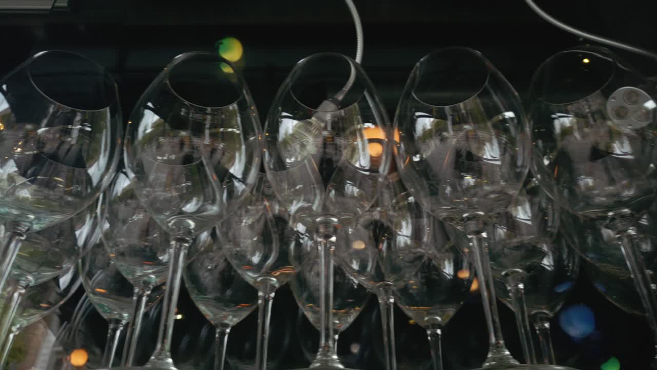 Plano de rastreamento paralelo de taças de vinho vazias e bem arrumadas, capturando a expectativa, a elegância e a calma antes do serviço em um ambiente de hospitalidade, destacando a cultura gastronômica e a preparação de eventos