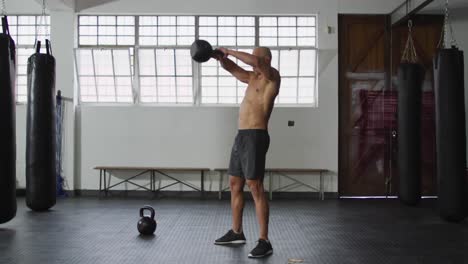 fit caucasian man working out with kettle bell at the gym