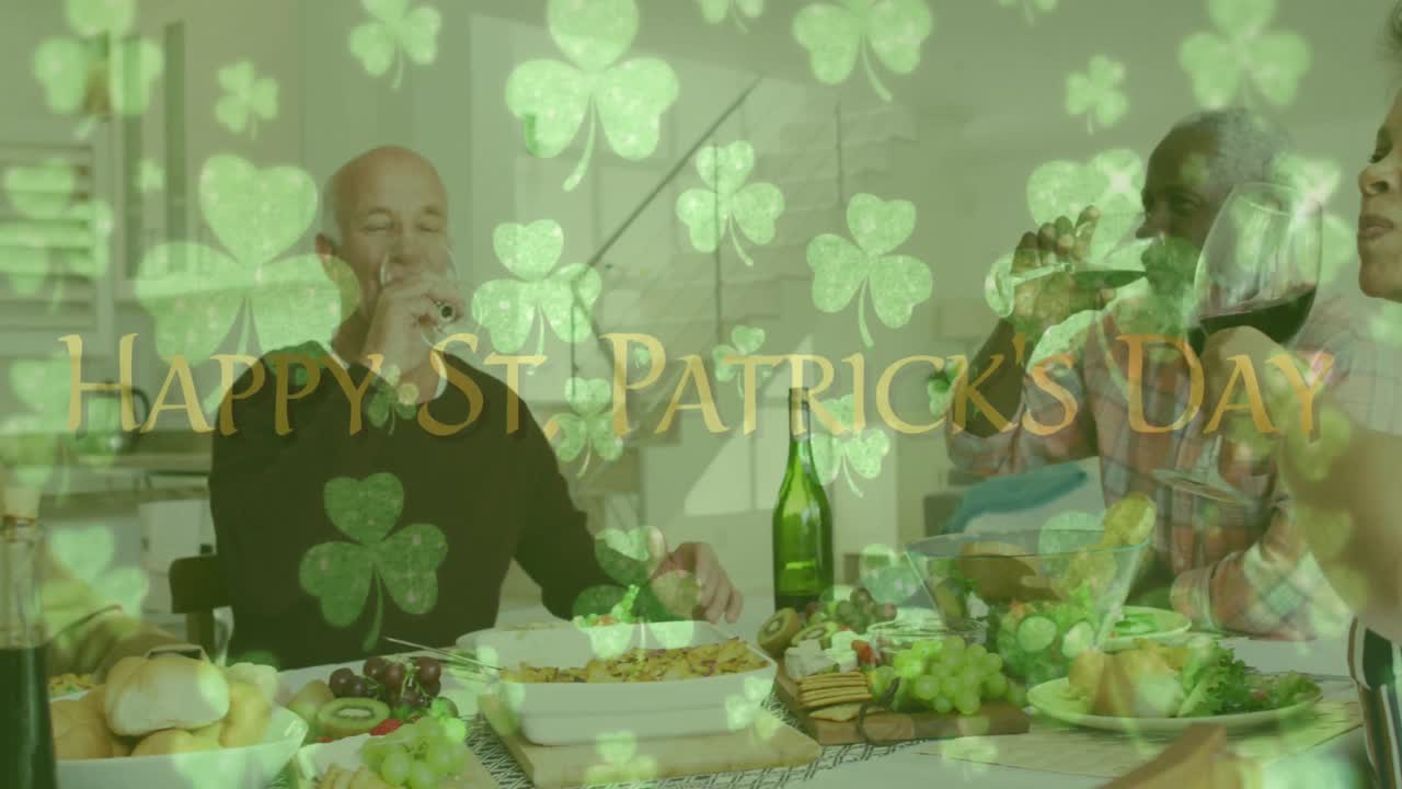 Animation of happy st patrick's day text with clover leaves over friends celebrating with wine