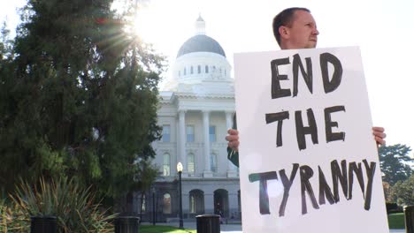 male political protester with end the tyranny sign