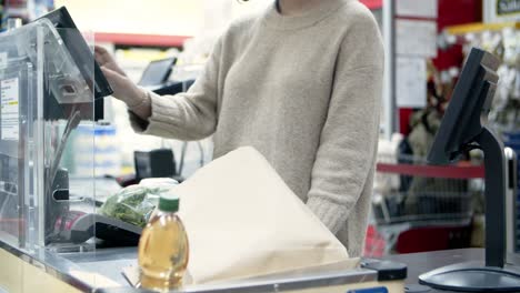 comprador en la caja registradora en una tienda de comestibles