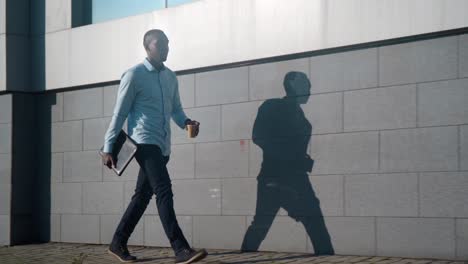 businessman walking with laptop and coffee