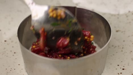 preparing beef tartare in a metal ring