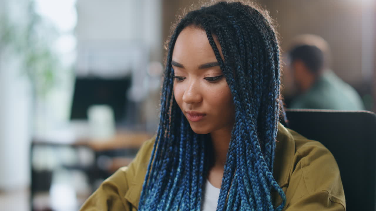 여성 매니저가 노트북을 타이핑하고 사무실에서 얼굴에 던진 종이에 놀랐습니다.