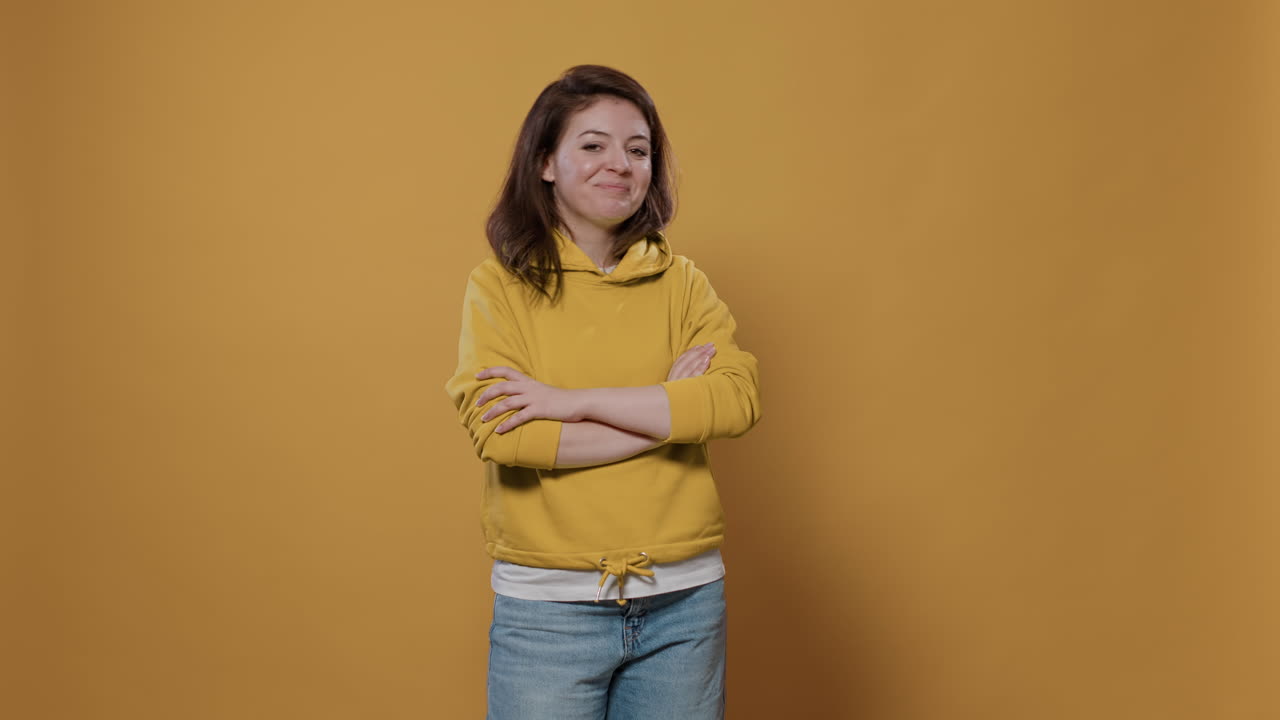 Woman in Yellow Hoodie with Crossed Arms