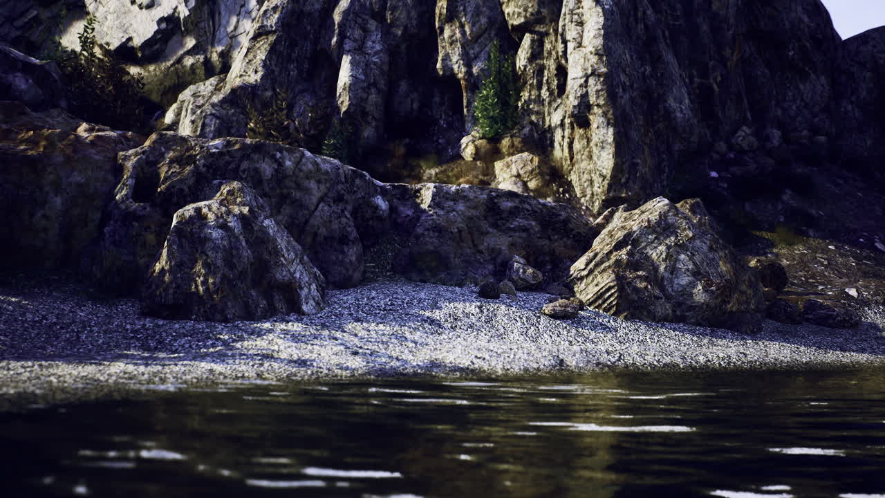 Rocky shoreline with calm water under evening light in natural landscape