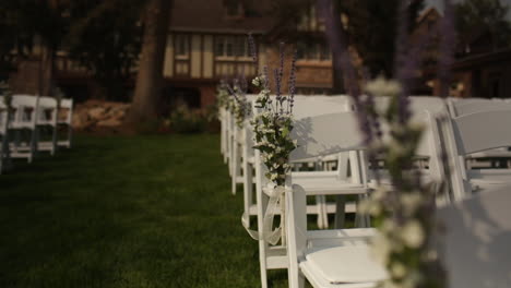 Dolly-Back,-Rack-Focus,-Hermosas-Flores-En-Boda-Exterior-Con-Sillas-Blancas