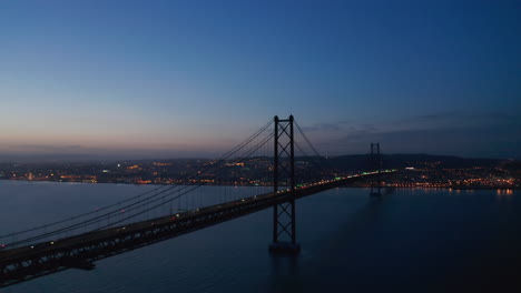 Vista-Aérea-Del-Tráfico-De-Automóviles-A-Través-Del-Mar-Sobre-El-Puente-Rojo-Ponte-25-De-Abril-En-Lisboa,-Portugal