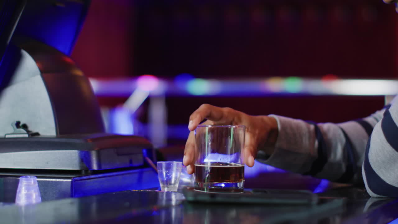Video of drunk african american man sitting drinking spirits at the bar