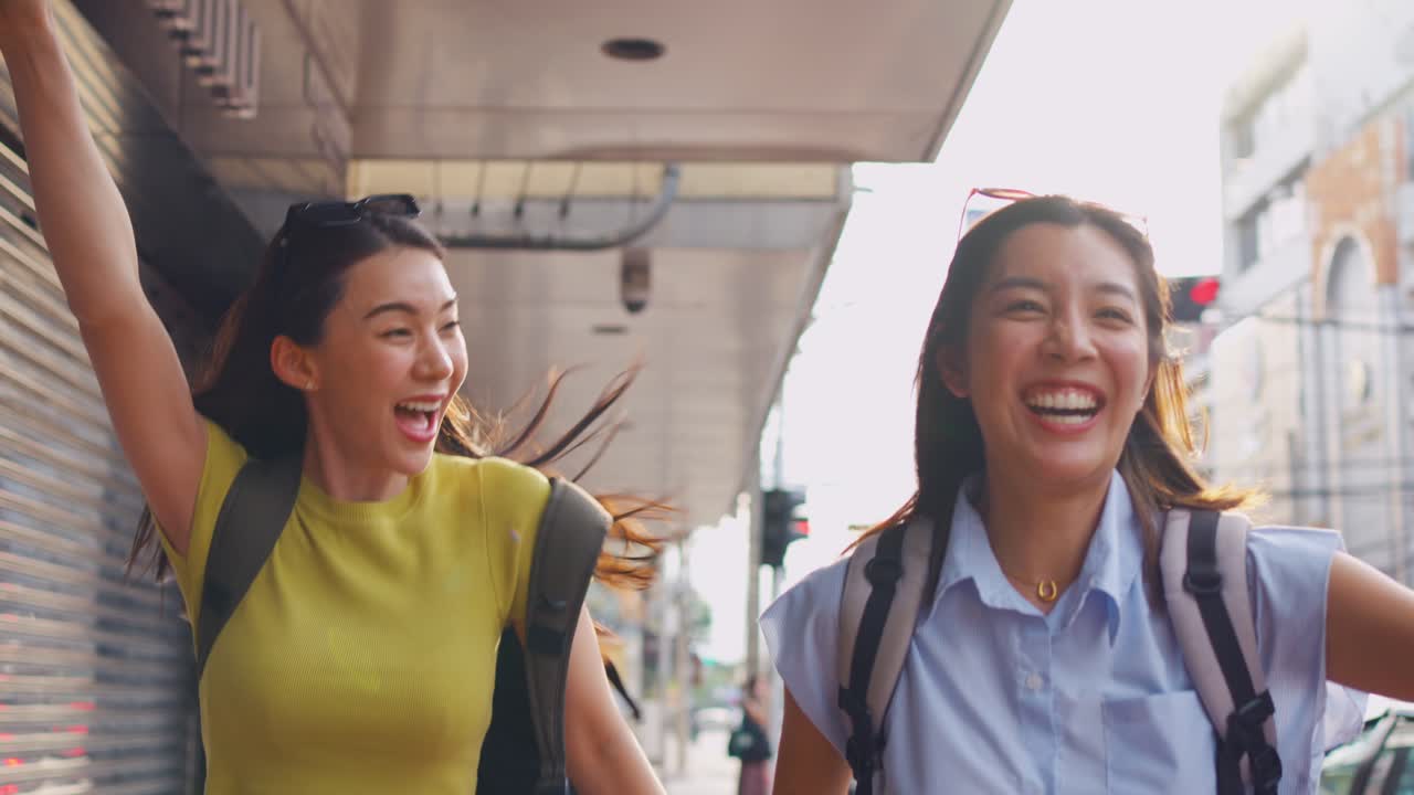 도시 거리에서 달리는 두 명의 행복한 여성 관광객