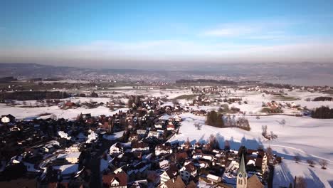 Schöne-Luftaufnahme-über-Ein-Kleines-Dorf-Auf-Einem-Hügel-Neben-Dem-Zürichsee