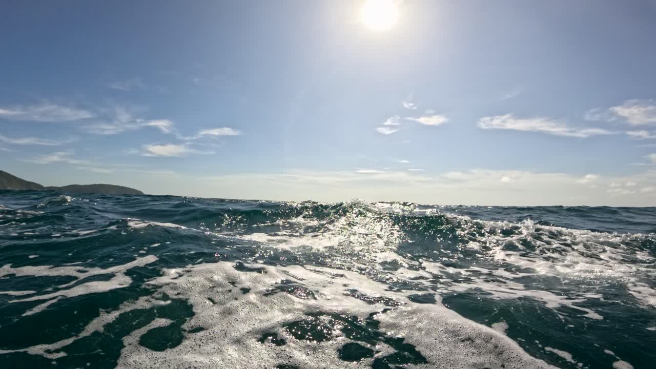 Dynamic ocean waves under a bright sun, captured near Phuket, Thailand. The video highlights the natural beauty and movement of the sea