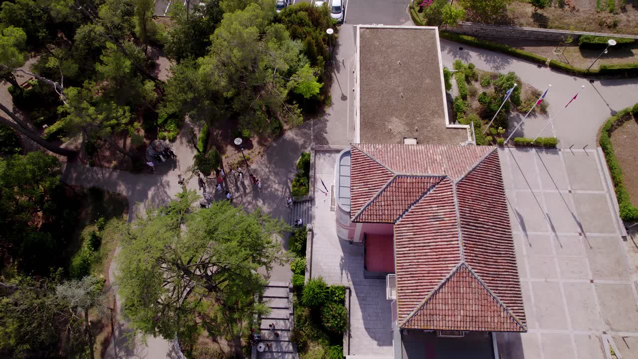 tomada de un avión no tripulado de un edificio con techo de terracota en medio de una exuberante vegetación