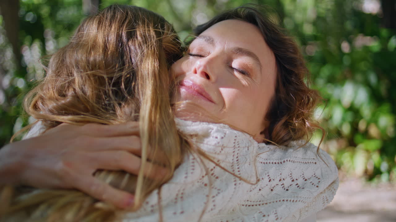 Portrait happy mom talking child walking at sunshine sprawling park