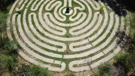 aerial rising shot of a maze walkway with a stone pathway exhibit