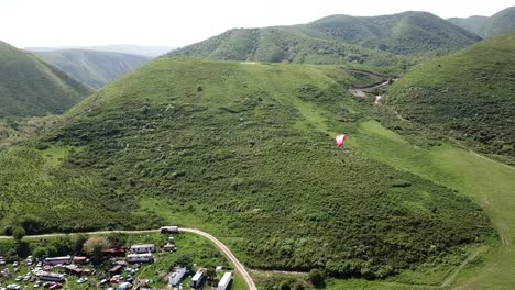 paragliding in the mountains. green fields, hills