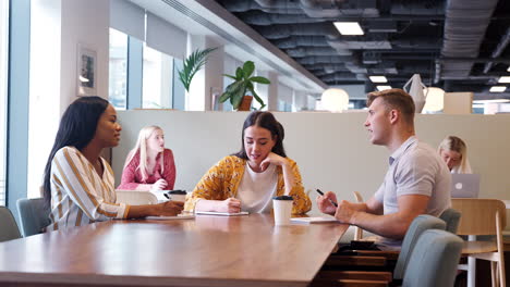 Group-Of-Young-Candidates-Sitting-Around-Table-And-Collaborating-On-Task-At-Business-Graduate-Recruitment-Assessment-Day