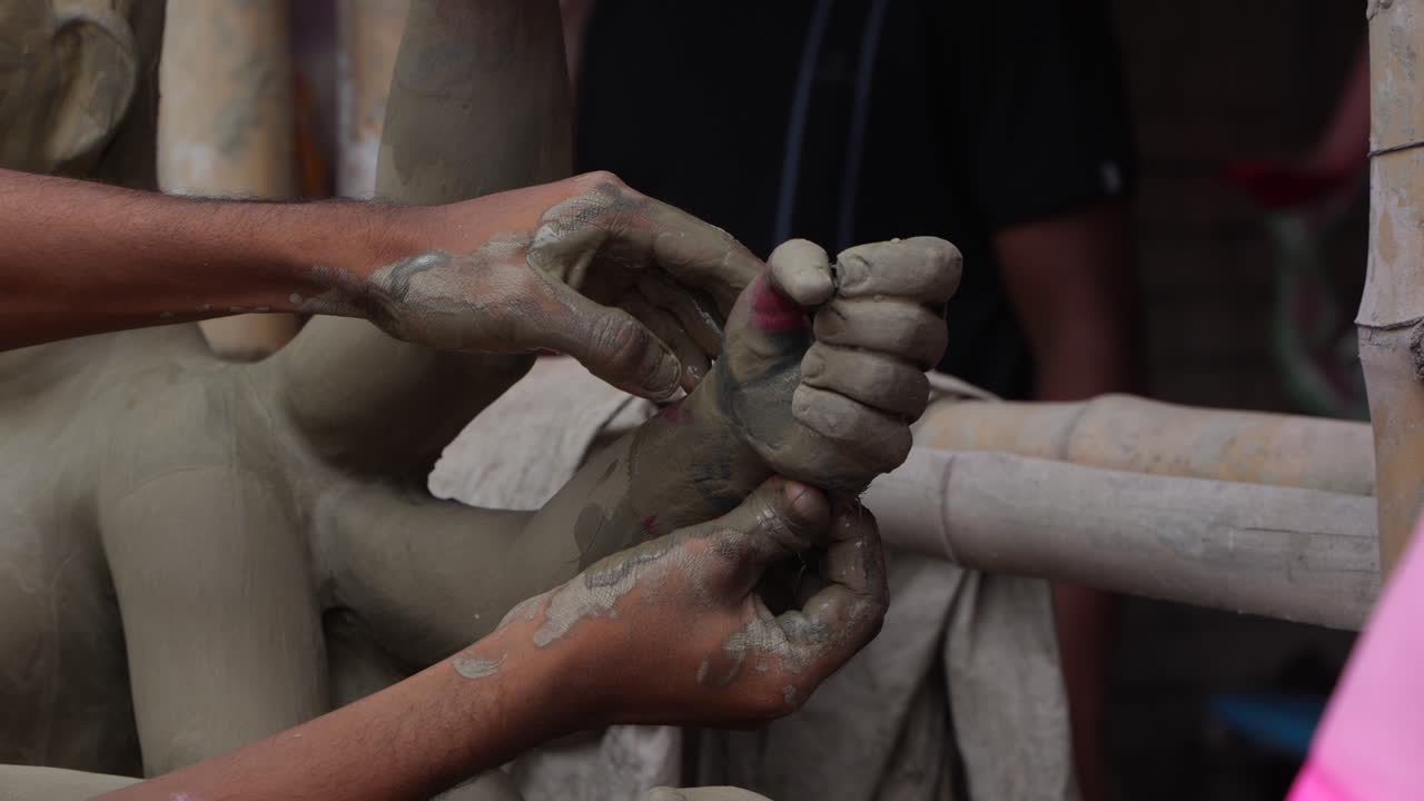 Hands shaping a clay statue: The art of sculpting Hindu deities
