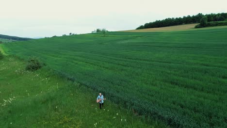 a woman plays the guitar near a field of oats