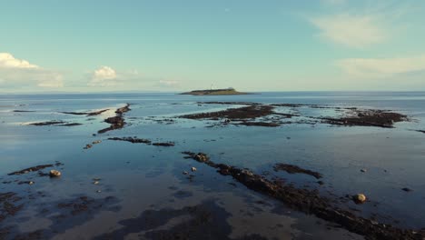 Aerial-view-of-Pladda-Lighthouse-on-the-Isle-of-Arran-on-a-sunny-day,-Scotland